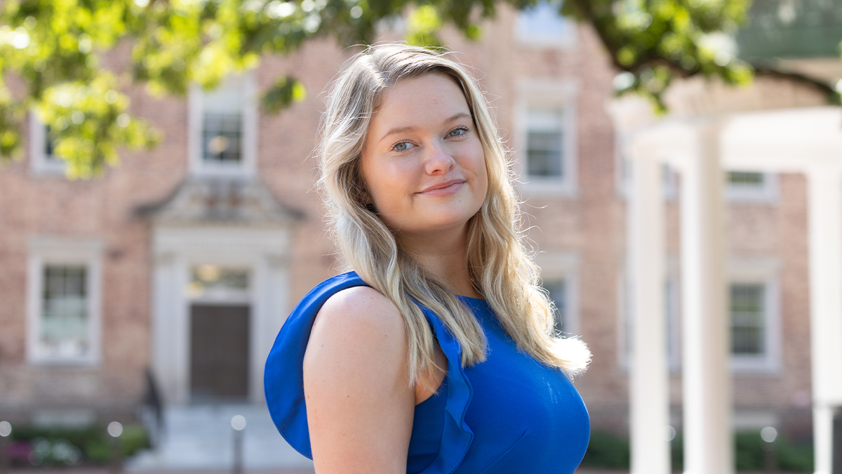 A student, Heather Norland, posing for a photo near the Old Well on the campus of UNC-Chapel Hill.